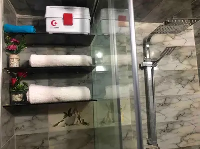 a bathroom with a glass shower stall with towels at Appartement en résidence in Marrakech