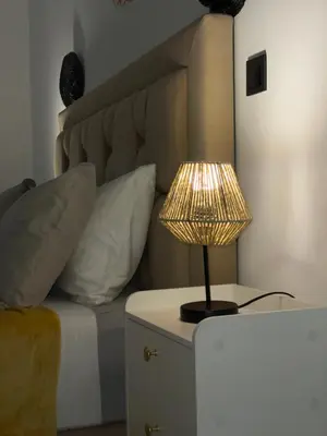 a lamp on a table next to a bed with pillows at M REVASION Appartement Golf27 in Marrakech