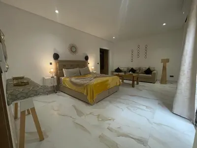 a bedroom with a king sized bed and a couch at M REVASION Appartement Golf27 in Marrakech