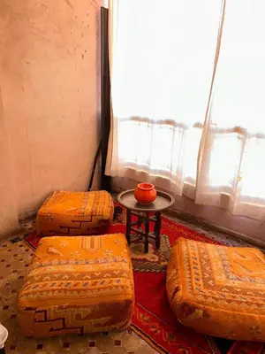 a room with two beds and a table and a window at Appartements de vacances in Marrakech