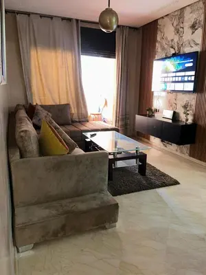 a living room with a couch and a glass table at Appartements de vacances in Marrakech