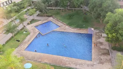 an overhead view of a large swimming pool with people in it at Premium village c1866 in Marrakech