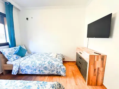 a bedroom with a bed and a tv in it at Le Coup de cœur de Guéliz avec Piscine et Parking in Marrakech