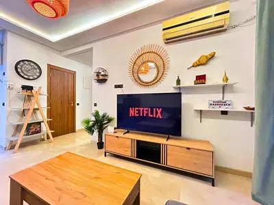 a living room with a television and a table at Le Coup de cœur de Guéliz avec Piscine et Parking in Marrakech