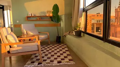 a living room with a chair and a window at Cozy & Bright Apartment with a Panoramic View in Marrakech