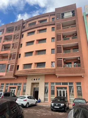 a building with cars parked in front of it at Cozy & Bright Apartment with a Panoramic View in Marrakech