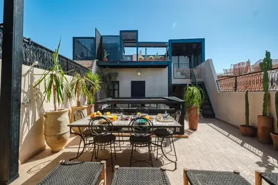 a patio with a table and chairs on a balcony at Riad Dar Davia - Jacuzzi Rooftop - Breakfast in Marrakech