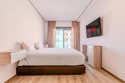 a bedroom with a bed and a tv on a wall at Bright and Stylish Apartment Center of Marrakech in Marrakech