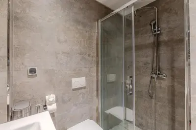 a bathroom with a shower with a toilet and a sink at Bright and Stylish Apartment Center of Marrakech in Marrakech