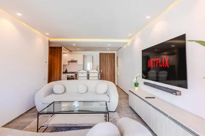 a living room with a white couch and a tv at Bright and Stylish Apartment Center of Marrakech in Marrakech