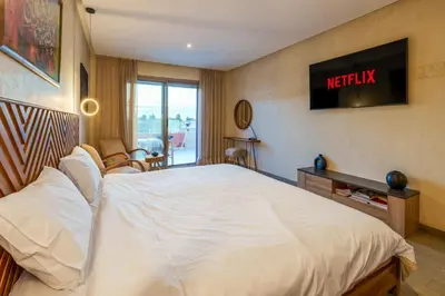 a hotel room with a bed and a television on the wall at Spacious Luxury Apartment with Heated Pool Center in Marrakech