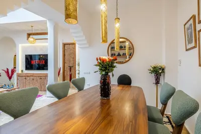 a dining room with a table with chairs and a vase with flowers at Riad Dar Catalia-Exclusive&HeatedPool-FreeBreakfas in Marrakech