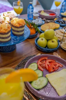 a table topped with plates of food and fruit at Riad Dar Catalia-Exclusive&HeatedPool-FreeBreakfas in Marrakech
