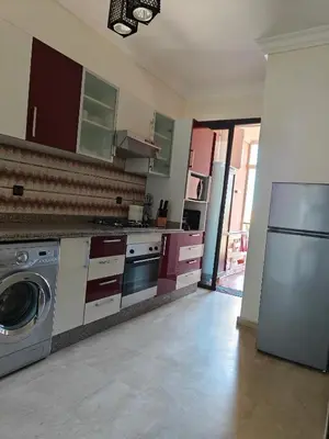 a kitchen with purple cabinets and a washer and dryer at Séjour Familial à Marrakech in Marrakech
