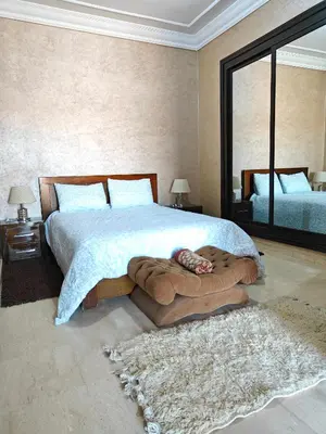 a bedroom with a large bed and a large mirror at Séjour Familial à Marrakech in Marrakech