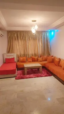 a living room with a couch and a table at Le stratégique a 10mn de l'aéroport face gare Ctm Hivernage in Marrakech