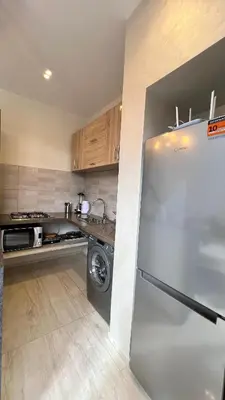 a kitchen with a refrigerator and a washer at Villa de rêve avec Piscine privée & Petit-déj gratuit in Ouled Rahou