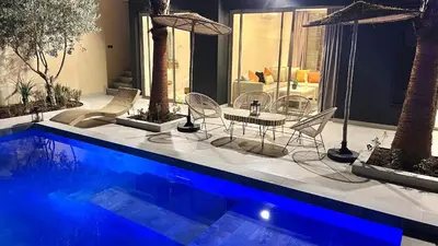 a patio with a table and chairs next to a pool at Villa de rêve avec Piscine privée & Petit-déj gratuit in Ouled Rahou