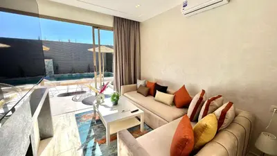 a living room with a couch and a table at Villa de rêve avec Piscine privée & Petit-déj gratuit in Ouled Rahou