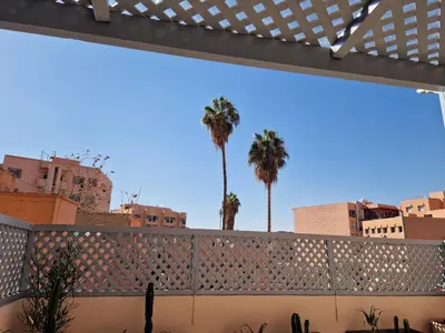 a fence with palm trees in the background at appartement hyper centre Gueliz in Marrakech