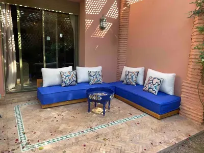 a blue couch sitting on a patio with a table at Dar lala habiba in Marrakech