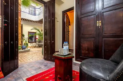a hallway with a door and a chair in a room at Riad Kamal Deluxe in Marrakech