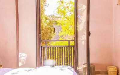 a man laying in a bed looking out a window at Waky Club - Designer Flat in Marrakech