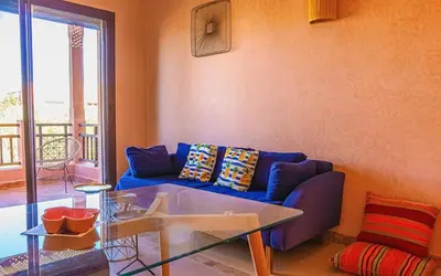 a living room with a blue couch and a glass table at Waky Club - Designer Flat in Marrakech