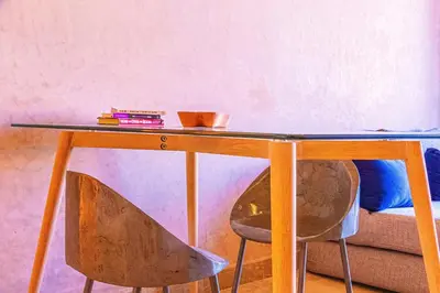 a wooden table with a chair in a room at Waky Club - Designer Flat in Marrakech