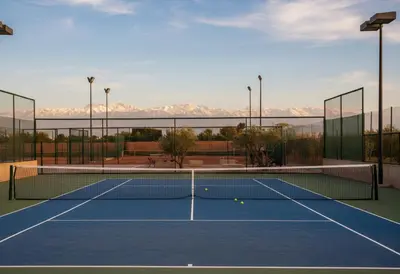 a tennis net on a tennis court with mountains in the background at Waky Club - Designer Flat in Marrakech
