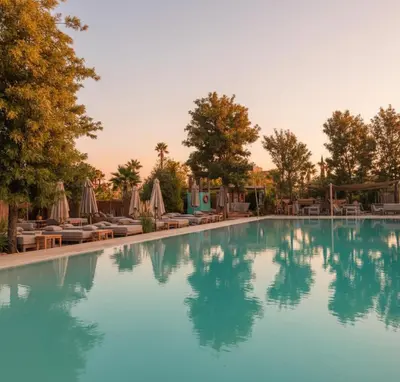 a swimming pool with chairs and umbrellas at a resort at Waky Club - Designer Flat in Marrakech