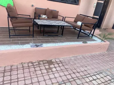 a patio with two chairs and a table at Cosy appartement avec piscine in Marrakech