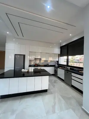 a large kitchen with white cabinets and black appliances at Villa Marrakech karim in Marrakech