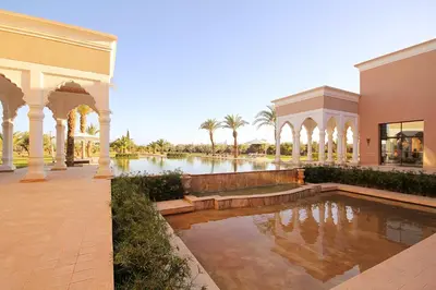 a building with a pool of water in a courtyard at Palais Les Orchidées - Villa de Luxe à 15 minutes du Centre in Marrakech