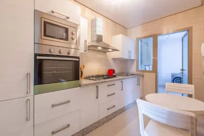 a kitchen with white cabinets and a microwave and a table at Heavenly Setting at Prestigia Pool in Marrakech