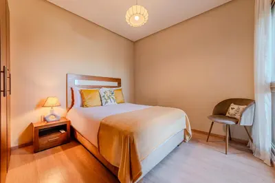 a bedroom with a bed and a chair at Serenity and Confort in Prestigia 10 min du centre in Marrakech