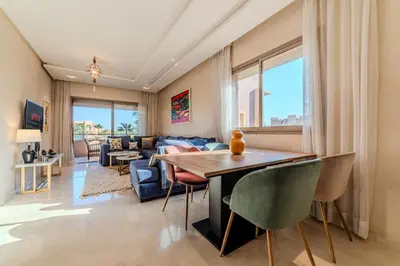 a living room with a table and chairs at Serenity and Confort in Prestigia 10 min du centre in Marrakech