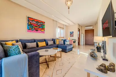 a living room with a blue couch and a table at Serenity and Confort in Prestigia 10 min du centre in Marrakech