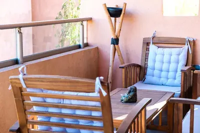 a porch with a chair and a table with a lamp at Serenity and Confort in Prestigia 10 min du centre in Marrakech