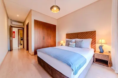 a bedroom with a large bed with a wooden headboard at Serenity and Confort in Prestigia 10 min du centre in Marrakech