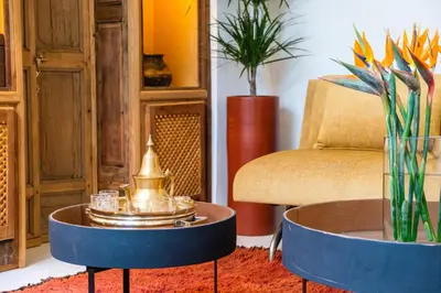 a living room with a coffee table and a chair at Riad Grenade Exclusif Front Bahia in Marrakech