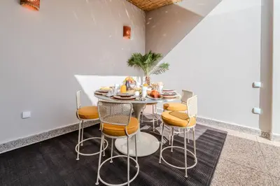 a dining room with a table and chairs at Riad Grenade Exclusif Front Bahia in Marrakech