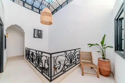 a room with a balcony with a chair and a potted plant at Riad Ines 10mn to Place with Breakfast in Marrakech