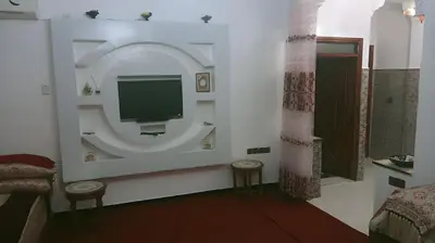 a room with a tv on a wall with stools at Spacious Apt - Near Airport - Perfect for Groops! in Marrakech