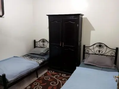 a bedroom with two twin beds and a cabinet at Spacious Apt - Near Airport - Perfect for Groops! in Marrakech