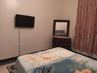 a bedroom with a bed with a dresser and a mirror at Spacious Apt - Near Airport - Perfect for Groops! in Marrakech