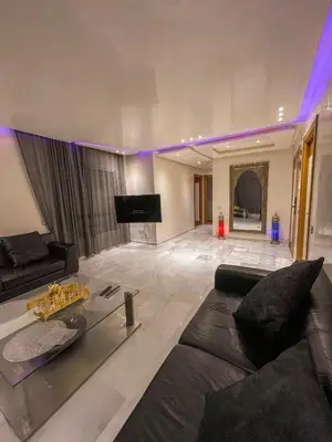 a large living room with a couch and a television at Luxury Appartement in Marrakech
