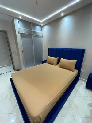 a large bed with a blue headboard in a room at Appartement Zen in Marrakech