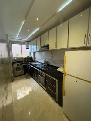 a kitchen with white cabinets and a refrigerator at Appartement Zen in Marrakech