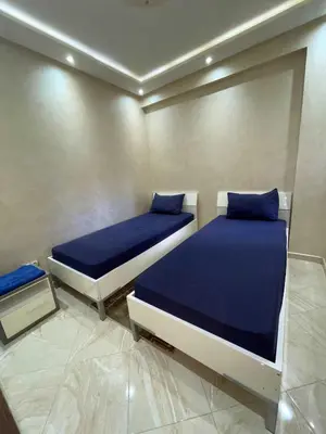 two beds with blue pillows in a room at Appartement Zen in Marrakech